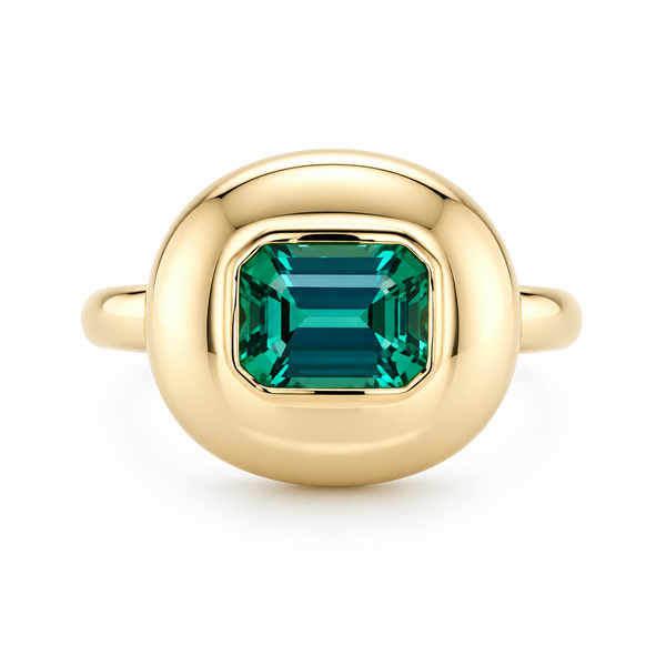A gold ring featuring a large, cushion-cut emerald-cut green gemstone, presented on a clean white background.